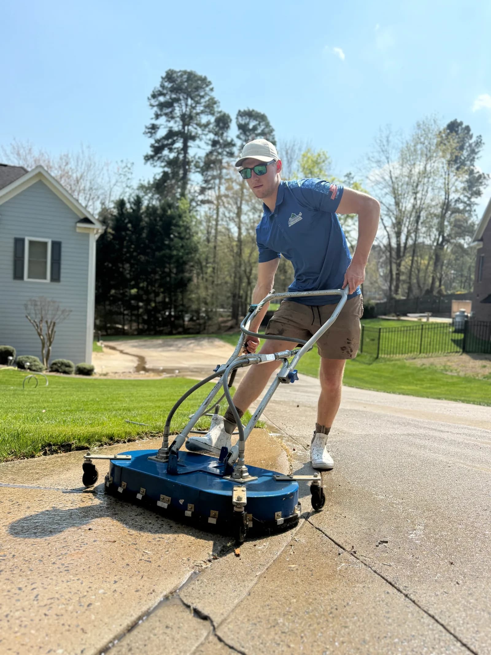 Ridge Curwood pressure washing a concrete driveway with a surface cleaner in Mooresville NC