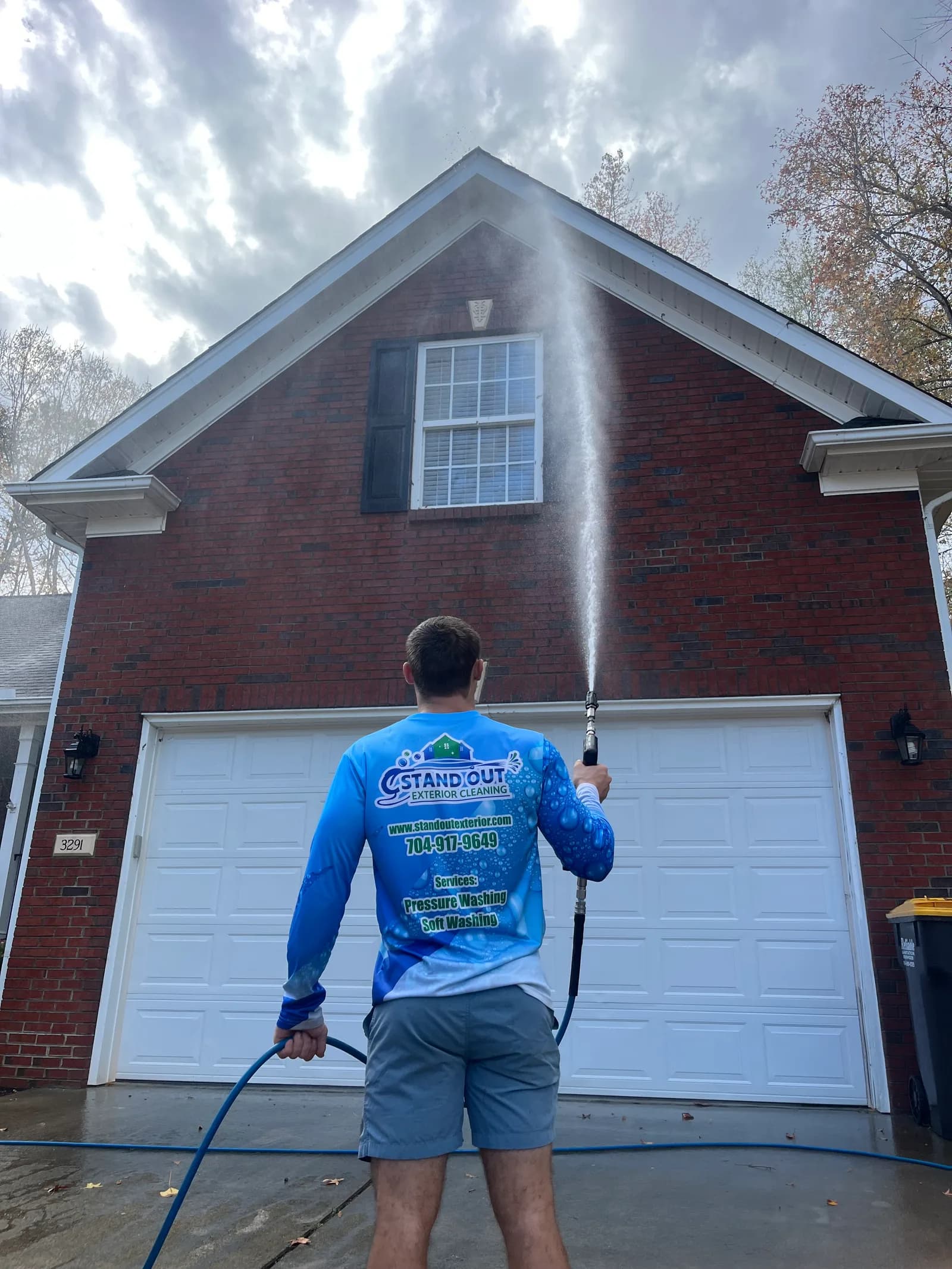 Ridge Curwood soft washing the brick and vinyl exterior of a home in Denver NC, removing algae and mildew