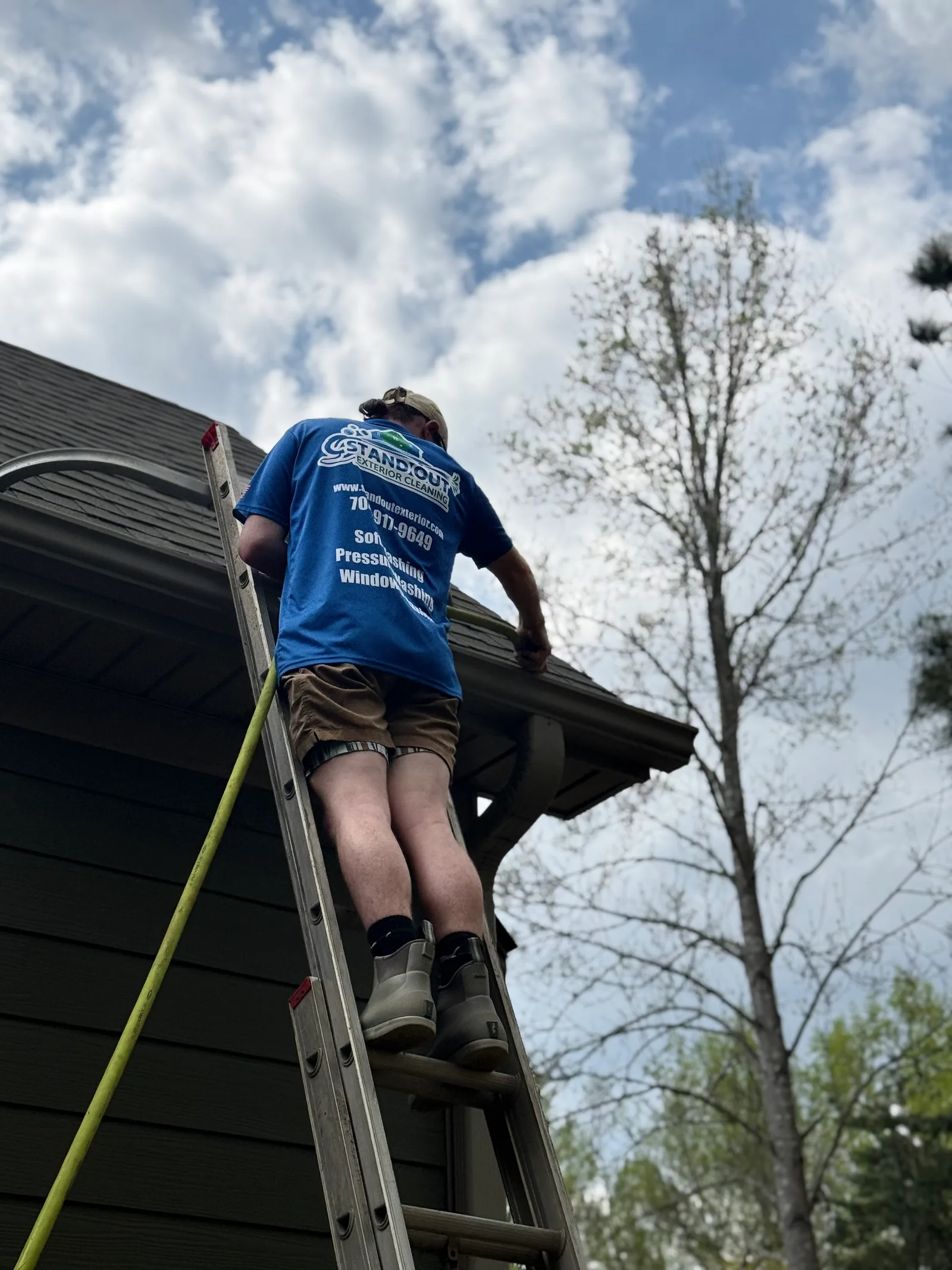 Ridge Curwood on a ladder cleaning gutters on a home in Sherrills Ford NC