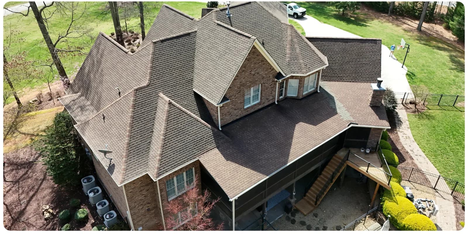 Aerial view of a soft-washed asphalt shingle roof in Huntersville NC with black algae streaks removed